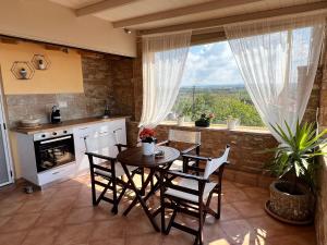 eine Küche mit einem Tisch und Stühlen sowie einem Fenster in der Unterkunft DoorMat# Wait 'N Sea, Jacuzzi, Luxury Stone House in Epanomi