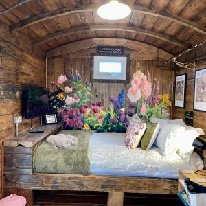 a bedroom with a bed with flowers on the wall at Skipbridge Farm Glamping in Green Hammerton
