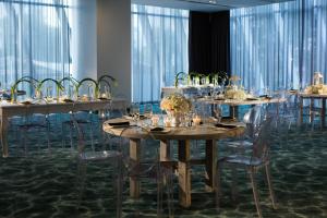 a group of tables and chairs with glasses on them at AC Hotel by Marriott Guadalajara Mexico in Guadalajara