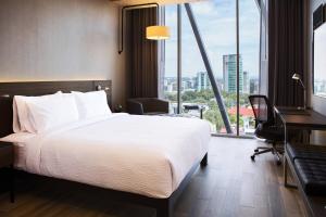 een hotelkamer met een bed, een bureau en een raam bij AC Hotel by Marriott Guadalajara Mexico in Guadalajara