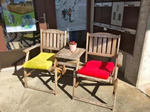 duas cadeiras de madeira e uma mesa e uma cadeira com um assento vermelho em Ferienwohnung Casa Margherita "Fischer" mit Traumaussicht em Rigi Kaltbad