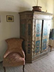 un gran armario de madera en una habitación con silla en Ferienwohnung Casa Margherita "Fischer" mit Traumaussicht, en Rigi Kaltbad