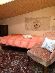 ein Schlafzimmer mit einem Bett, einem Stuhl und einem Sofa in der Unterkunft Ferienwohnung Casa Margherita mit Traumaussicht in Rigi Kaltbad