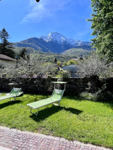 dos sillas de césped sentadas en el césped con montañas en el fondo en Casa Unica- da Bruno en Colico