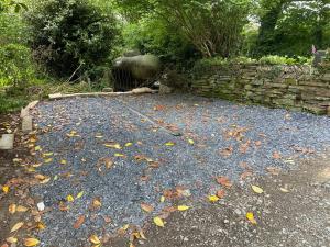 a pile of leaves on the ground next to a stone wall at Rural cosy retreat for two near Port Isaac in Delabole