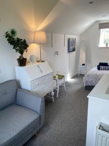 a living room with a couch and a bed at Rural cosy retreat for two near Port Isaac in Delabole