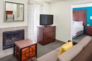 ein Wohnzimmer mit einem Sofa, einem TV und einem Bett in der Unterkunft Residence Inn Seattle South/Tukwila in Tukwila