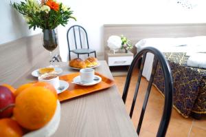 a table with a tray of food and fruit on it at Hotel Centrale in Milan