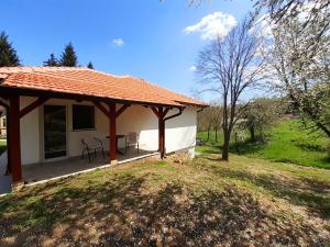 ein Haus mit einer Veranda mit zwei Stühlen darauf in der Unterkunft Apartman Predah Banja Vrujci in Gornja Toplica