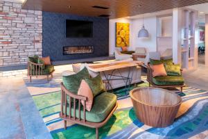 vestíbulo con sillas, mesa y chimenea en Fairfield Inn & Suites by Marriott Fair Oaks Farms en Fair Oaks