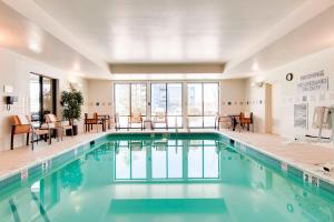 una piscina in una stanza d'albergo con tavoli e sedie di Courtyard Philadelphia Great Valley/Malvern a Malvern
