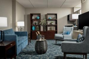 a living room with a couch and two chairs and a table at Four Points by Sheraton Milwaukee North Shore in Brown Deer