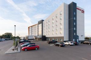 TownePlace Suites by Marriott Edmonton South في إيدمونتون: مبنى كبير به سيارات تقف في موقف للسيارات