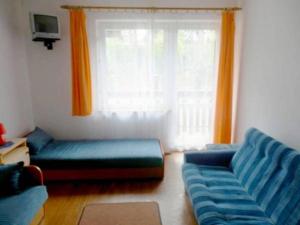a living room with a blue couch and a window at Dom gościnny Moana in Pobierowo