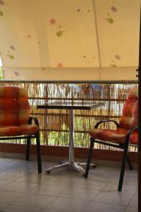 Duas cadeiras debaixo de uma mesa numa varanda em Dimitri's House em Nafplio