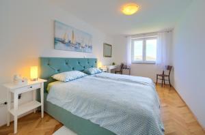 a bedroom with a large bed with a blue headboard at Apartment Frane in Baška