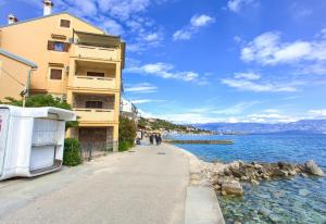 a sidewalk next to a building next to a body of water at Apartment Frane in Baška