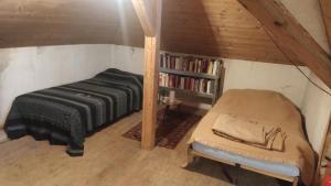 a attic room with a bed and a book shelf at Waldhaus auf dem Randen, Kanton Schaffhausen 