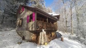 a cabin in the snow with pink windows at Waldhaus auf dem Randen, Kanton Schaffhausen 