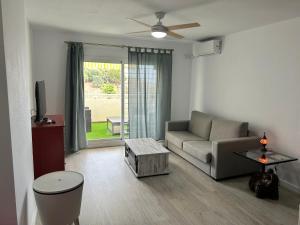 ein Wohnzimmer mit einem Sofa und einem Tisch in der Unterkunft FUENGIROLA Castillo Malaga PARADAISE 3 in Fuengirola