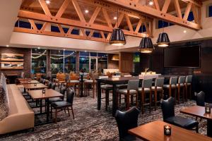 サンカルロスにあるResidence Inn by Marriott Redwood City San Carlosのテーブルと椅子、薄型テレビ付きのレストランを提供しています。