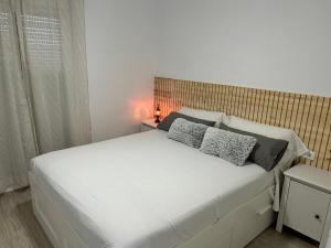 sypialnia z dużym białym łóżkiem z 2 poduszkami w obiekcie FUENGIROLA Castillo Malaga PARADAISE 3 w mieście Fuengirola