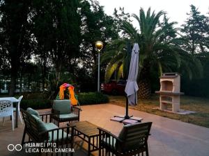 patio con tavolo, sedie e ombrellone di La Torretta a Piombino