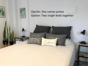 a bedroom with a bed with two pillows on it at Via Buenos Aires- Studio Microcentro in Buenos Aires +18 photos