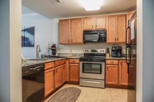 a kitchen with wooden cabinets and stainless steel appliances at Mvc - Unit 5606 - Mountain Breeze 2 in Pigeon Forge