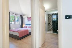 a bedroom with a bed with a pink blanket at Penthouse Nensi in Baška Voda