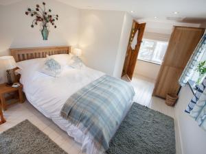 a bedroom with a large white bed in a room at Ford Hill Cottage in East Down