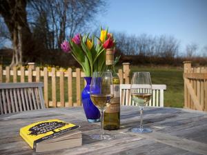 a table with a bottle of wine and two glasses at Ford Hill Cottage in East Down