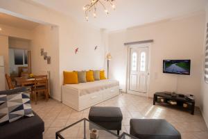 a living room with a bed with yellow pillows at Apartment with view in Kiveri, near Nafplio in Kivérion