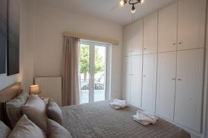 a bedroom with a bed and a large window at Apartment with view in Kiveri, near Nafplio in Kivérion