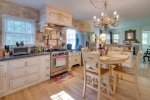 uma cozinha com uma mesa e um fogão forno superior em Le Canard Cottage with Porch 10 Mi to Asheville! em Arden