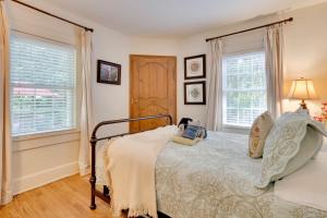 um quarto com uma cama e duas janelas em Le Canard Cottage with Porch 10 Mi to Asheville! em Arden