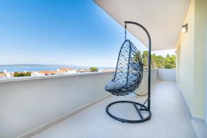 a swing on a balcony with a view of the ocean at Penthouse Nensi in Baška Voda