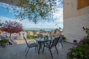 a patio with a table and chairs on a balcony at Apartment with view in Kiveri, near Nafplio in Kivérion
