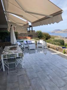 a patio with a table and chairs and an umbrella at Appartamento vista mare Capo Falcone in Stintino +25 photos