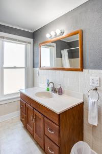 ein Bad mit einem Waschbecken und einem Spiegel in der Unterkunft Spacious Home with In-Unit Laundry, Parking, 1GB WiFi, & Patio Deck in Rochester