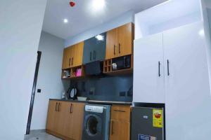een keuken met een wasmachine en een wasmachine bij Sylz Residence Studio 1- 5 Mins from Labadi & Laboma Beaches in Accra