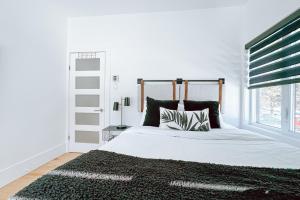 a bedroom with a white bed with a black rug at Complexe LIVTremblant by Gestion ELITE - LIV1 in Mont-Tremblant