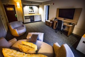 a hotel room with a couch and a desk and a television at Courtyard Memphis East/Bill Morris Parkway in Memphis