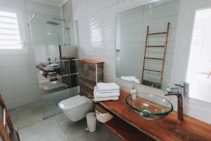 a bathroom with a glass sink and a toilet at Villas Riviera F4, Le Helleux, calme, lagon privé in Sainte-Anne