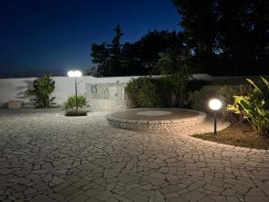 un patio de piedra por la noche con dos luces en Villa Eugenia in Campomarino di Maruggio, Puglia - casa vacanze, en Campomarino