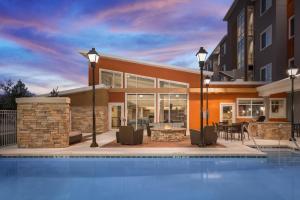 a villa with a swimming pool in front of a building at Residence Inn by Marriott Shreveport-Bossier City/Downtown in Bossier City