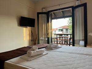 a hotel room with a bed with towels on it at Eden Hotel in Afitos