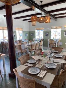 a dining room with a long table with plates and glasses at Liseleje Badehotel in Liseleje