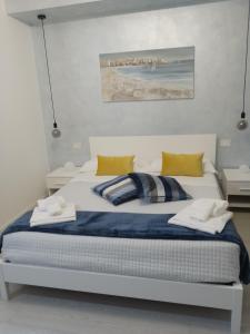 1 dormitorio con cama blanca y almohadas amarillas en Ad un passo dal mare, en Bari