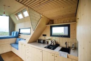 a kitchen in a tiny house with a sink at Tiny House Pioneer 17 Zur Meerseite - Green Tiny Village Harlesiel in Carolinensiel +21 photos